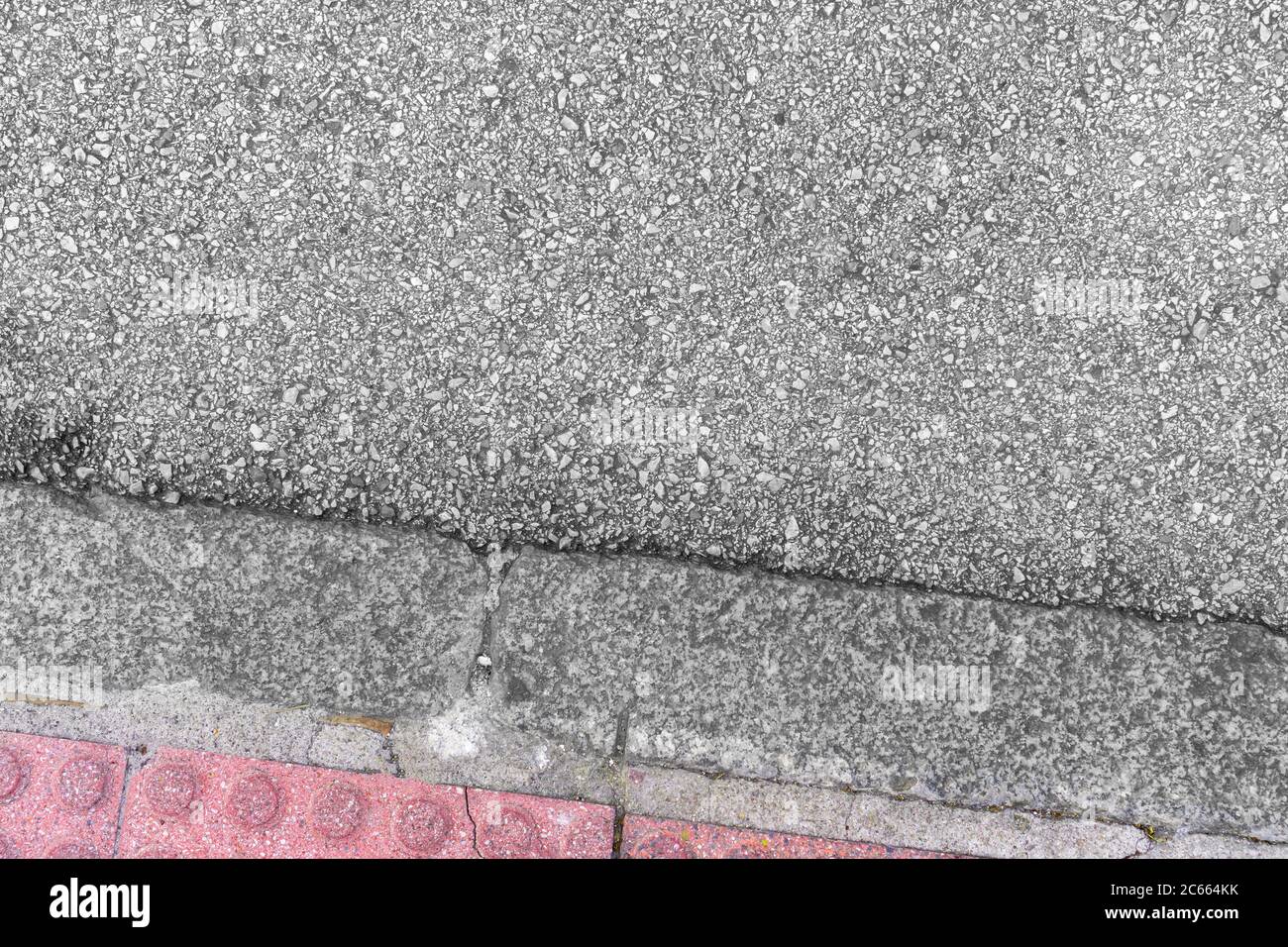 Gray asphalt and red road tiles. Early types of road surface. Copyspace