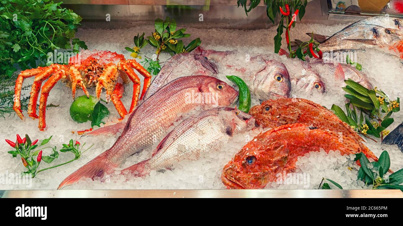 Raw fish and shellfish on iced supermarket display, toned Stock Photo