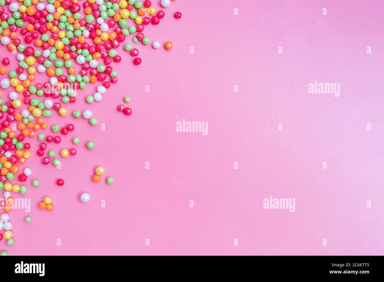 Decorative sugar sprinkles on a pink backdrop Stock Photo - Alamy