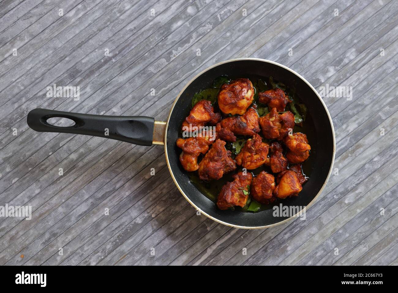 https://c8.alamy.com/comp/2C667Y3/chicken-fry-or-fried-chicken-kabab-which-is-well-garnished-with-curry-leaves-in-a-black-frying-pan-with-grey-background-2C667Y3.jpg