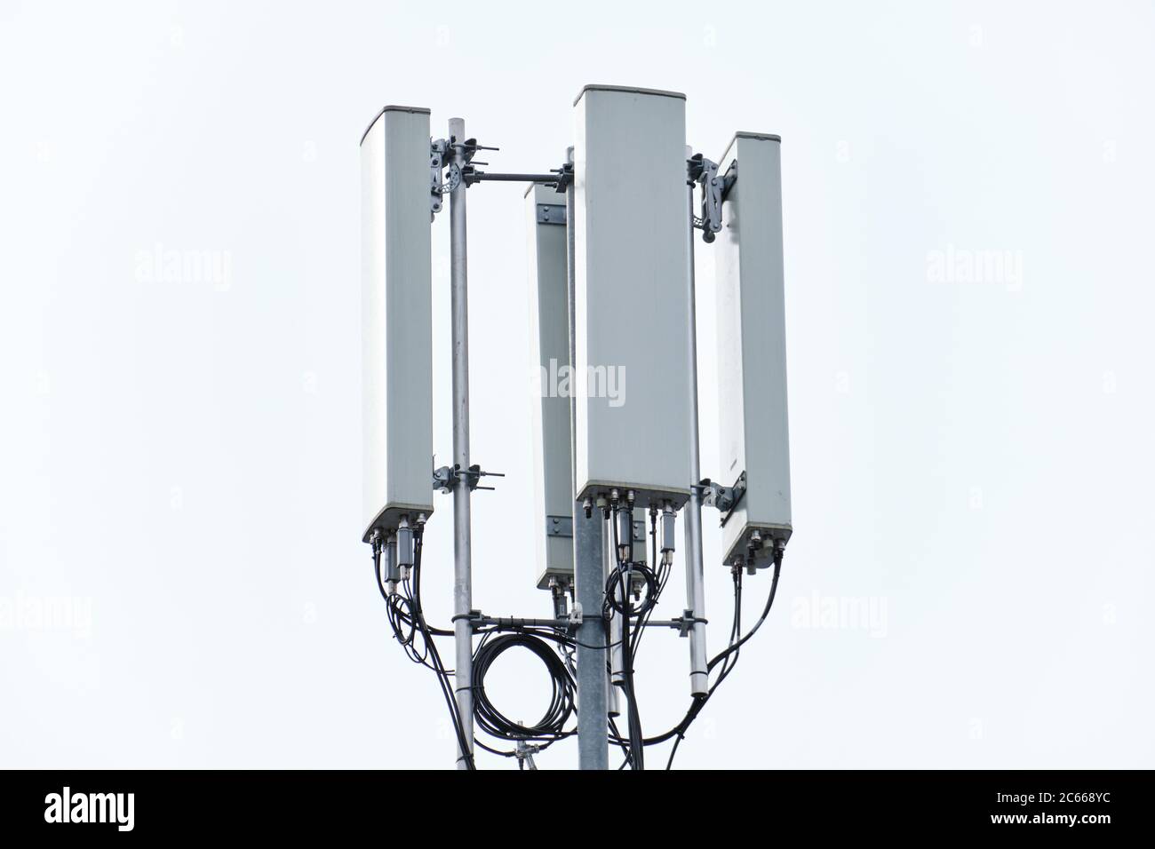 Cellular phone network telecommunication tower on the building roof. Stock Photo