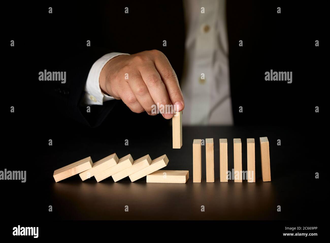 businessman hand stopping falling dominos. Business concept Stock Photo ...