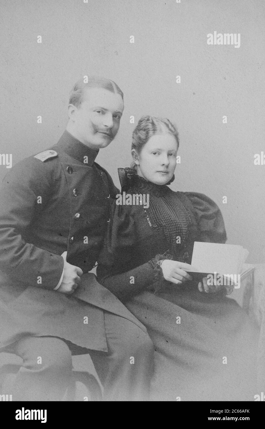 Couple in Berlin, in 1890, he in military uniform, she in a black dress to make a book, Germany  /  Ehepaar in Berlin, 1890, er in Militäruniform, sie im schwarzen vornehmen Kleid mit einem Buch, Deutschland, Historisch, historical, digital improved reproduction of an original from the 19th century / digitale Reproduktion einer Originalvorlage aus dem 19. Jahrhundert, Carte de visite, a type of small photograph which was patented in 1854, each photograph was the size of a visiting card, and such photograph cards were commonly traded among friends and visitors in the 1860s  /  Visitformat, Cart Stock Photo