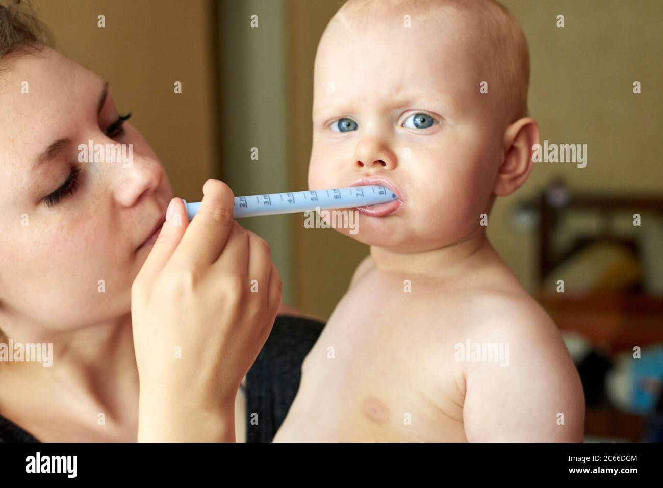 Mom gives her little child medicine through a syringe Stock Photo Alamy