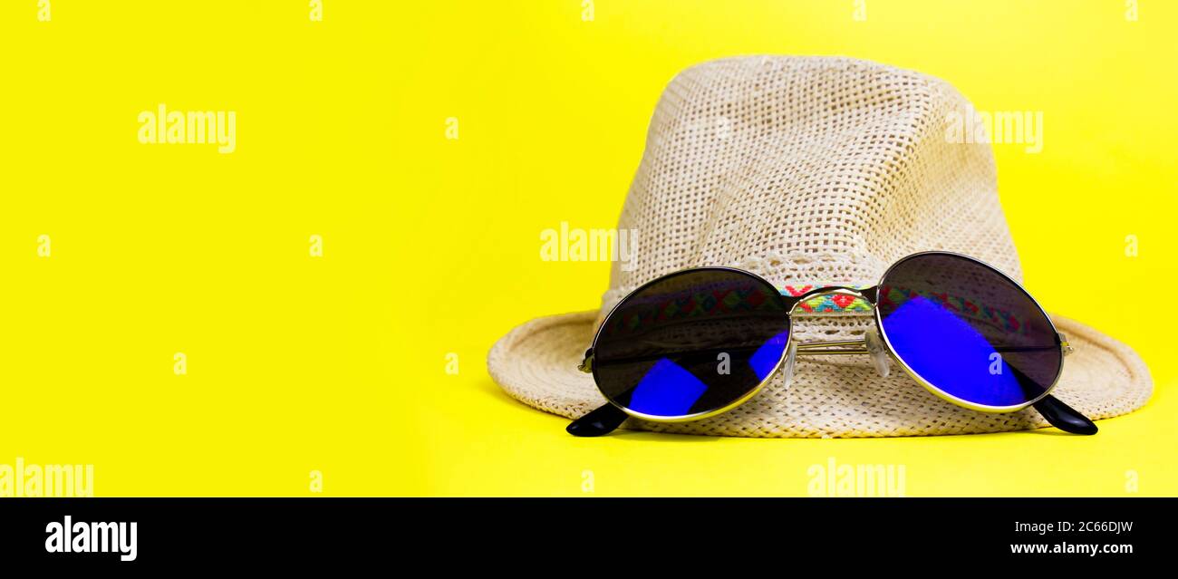 Womens summer straw hat with a brim, blue rounded sunglasses on yellow ...