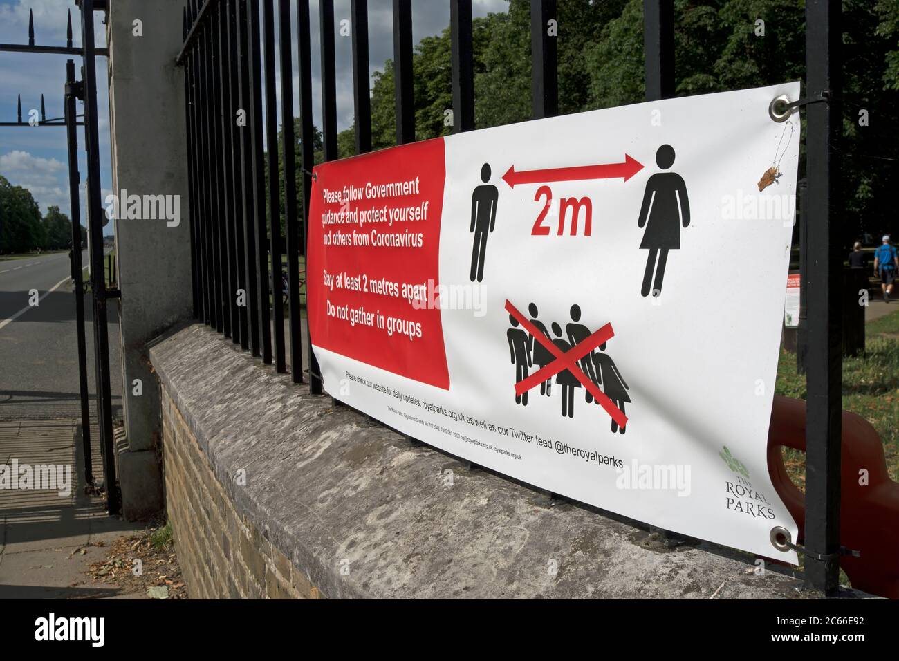 at the entrance to bushy park, southwest london, england, a royal parks banner describing covid-19 social distancing measures applicable in the park Stock Photo