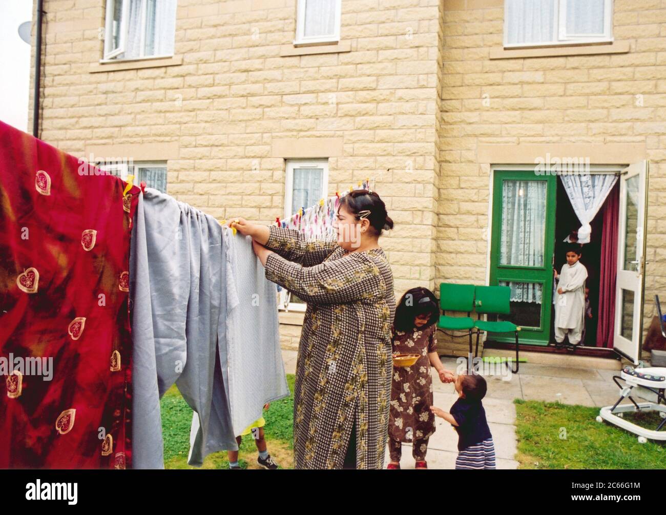 Mother hanging out washing with kids; Halifax; West Yorkshire Stock Photo