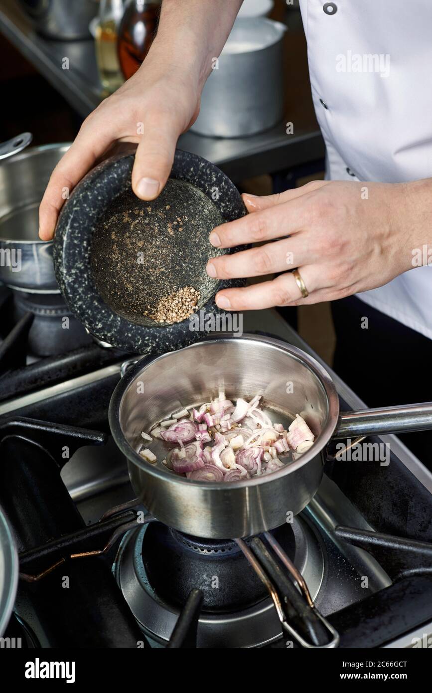 Process steps for preparing a Béarnaise sauce, addition of white pepper Stock Photo
