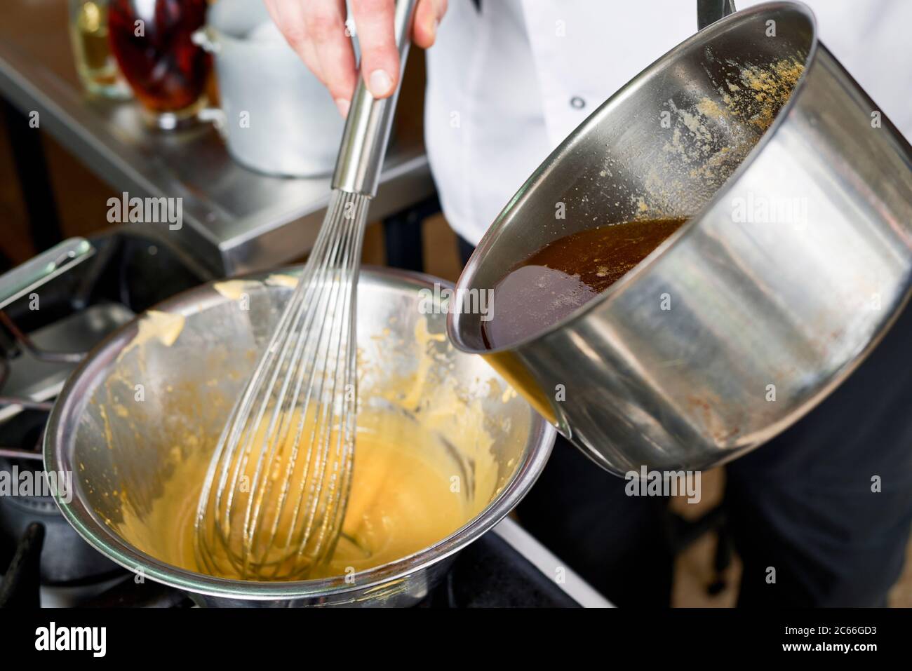 Preparation of Béarnaise Sauce step by step, clarified butter being added to the mixture Stock Photo
