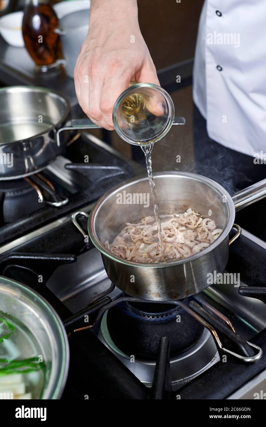 Preparation of Béarnaise Sauce step by step, white wine being added Stock Photo