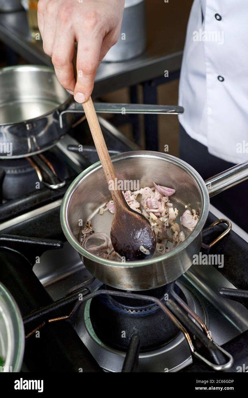 Preparation of Béarnaise Sauce step by step, shallots being stirred in the saucepan Stock Photo