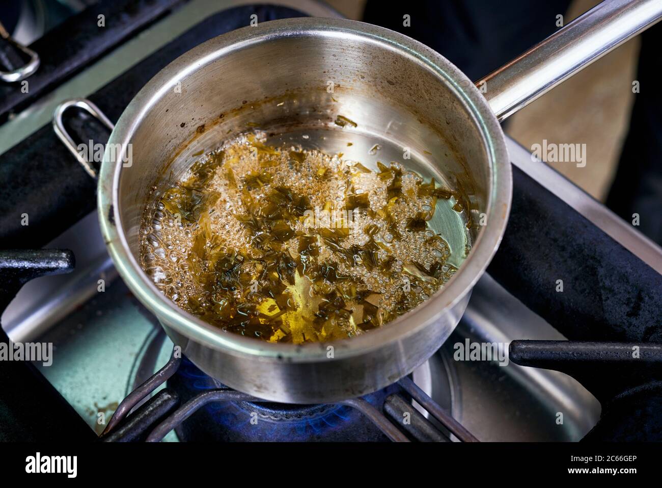 Preparation of Béarnaise Sauce step by step, wine and vinegar plus shallots and herbs being boiled and reduced Stock Photo