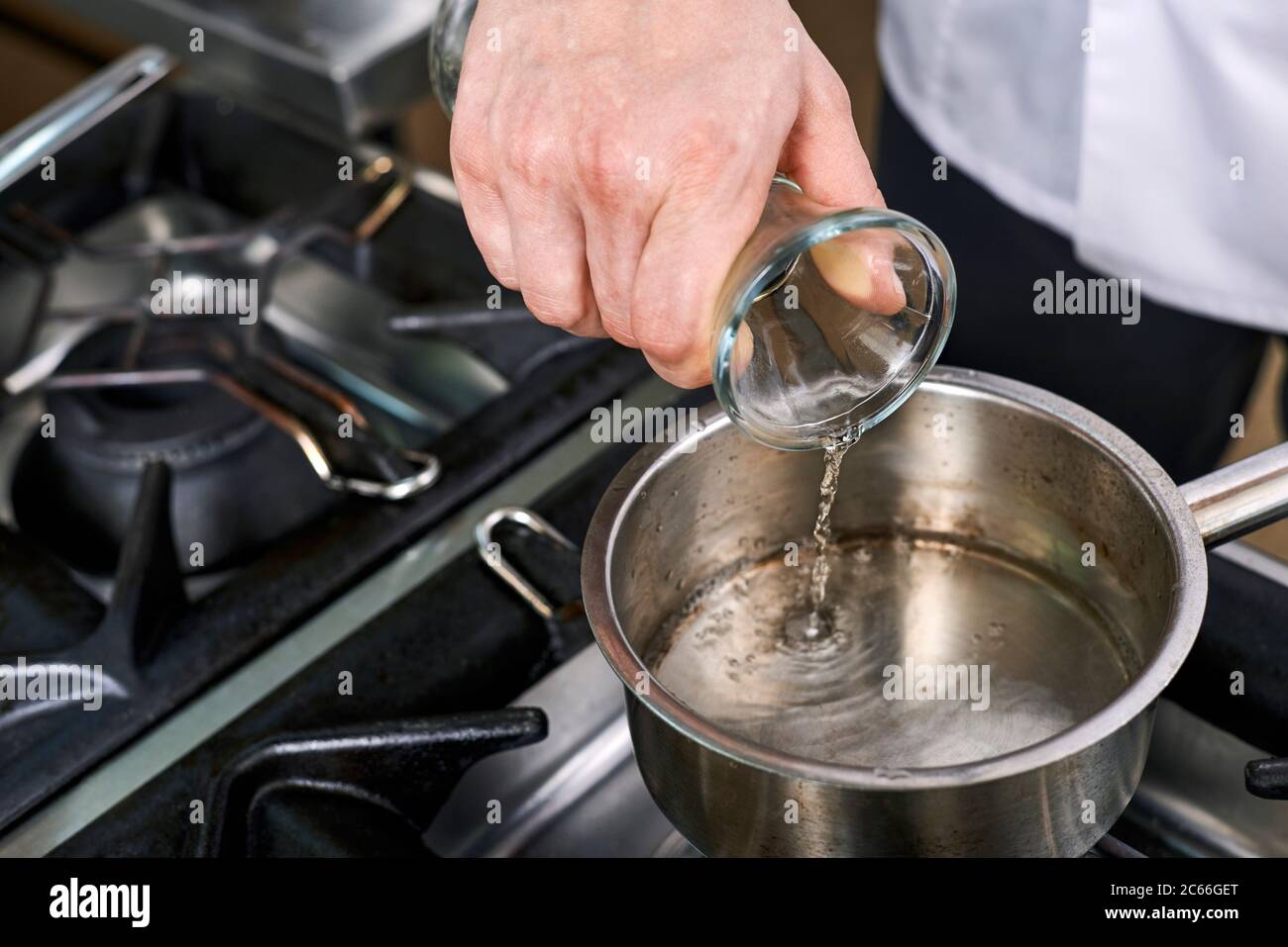 Preparation of Béarnaise Sauce step by step, water and wine being heated Stock Photo