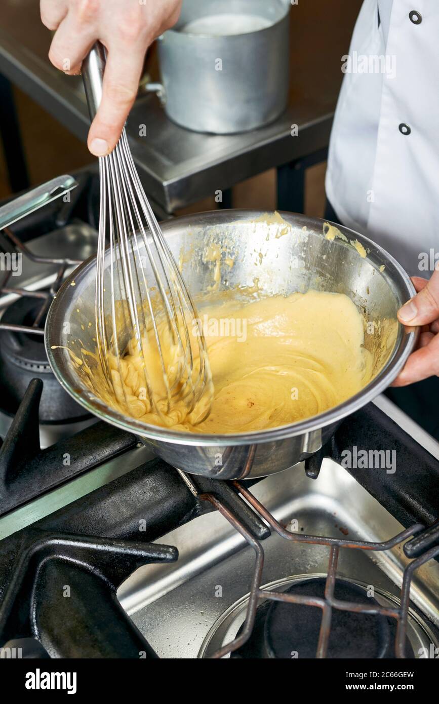 Preparation of Béarnaise Sauce step by step, mixture being whisked again Stock Photo