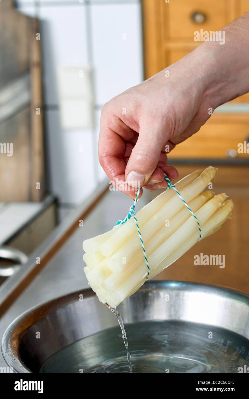 Preparation of asparagus with Béarnaise Sauce step by step, asparagus spears being removed from the simmering water Stock Photo