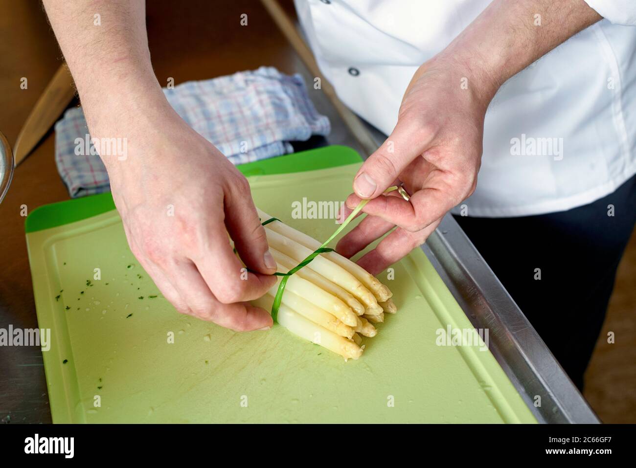 Preparation of asparagus with Béarnaise Sauce step by step, asparagus spears being bundled by using chives Stock Photo