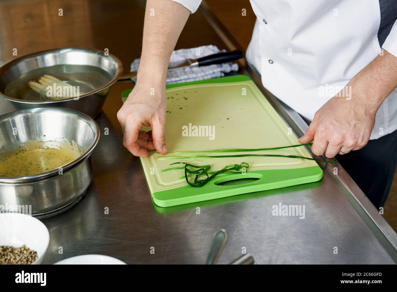Preparation of asparagus with Béarnaise Sauce step by step, lightly steamed chives being laid out Stock Photo