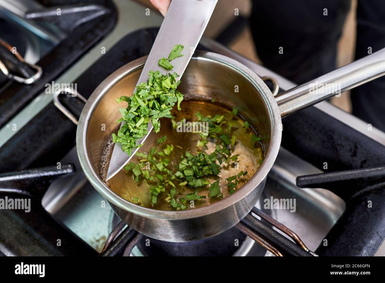 Preparation of Béarnaise Sauce step by step, finely chopped tarragon being added Stock Photo
