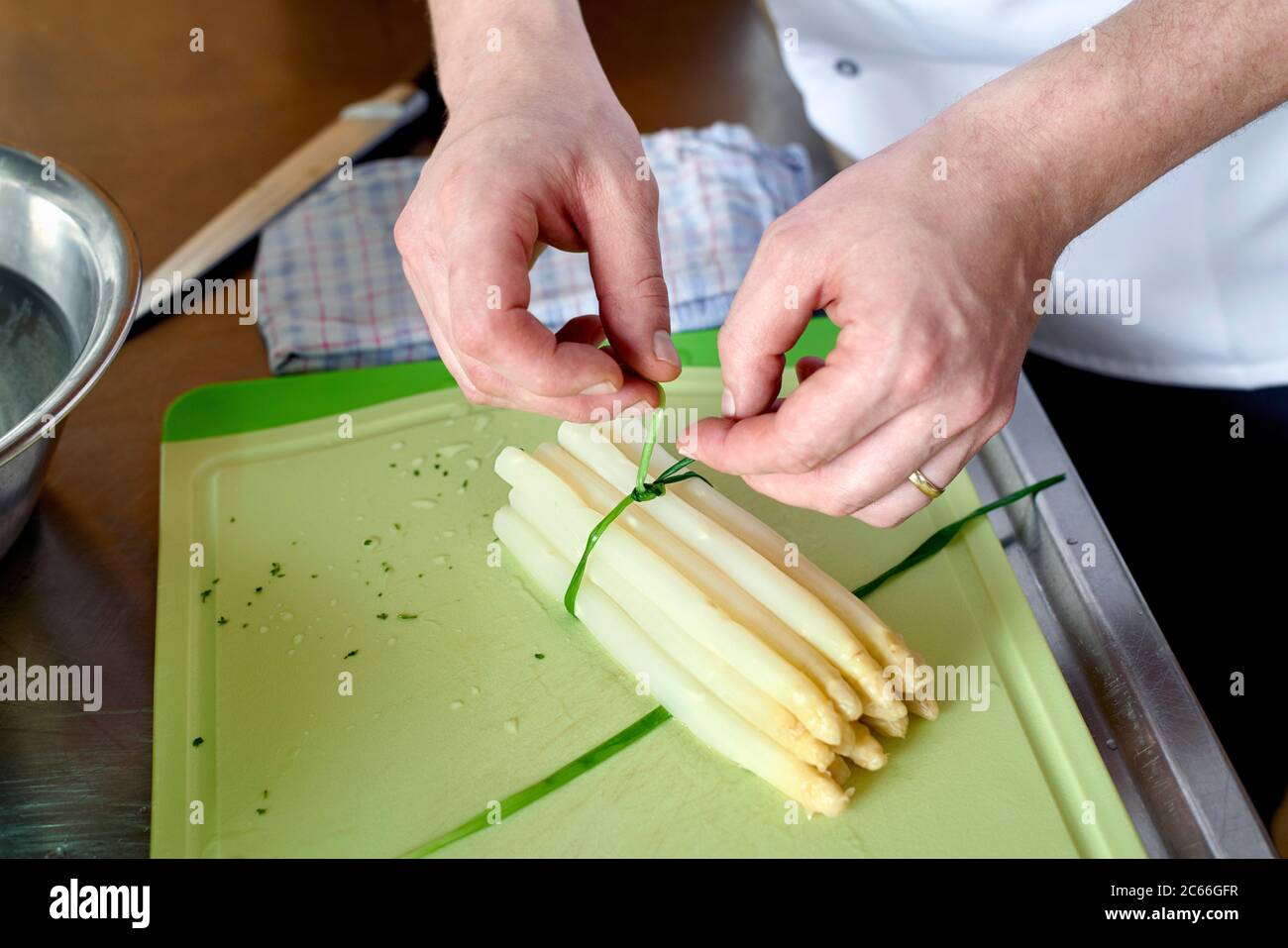 Preparation of asparagus with Béarnaise Sauce step by step, asparagus spears being bundled by using chives Stock Photo