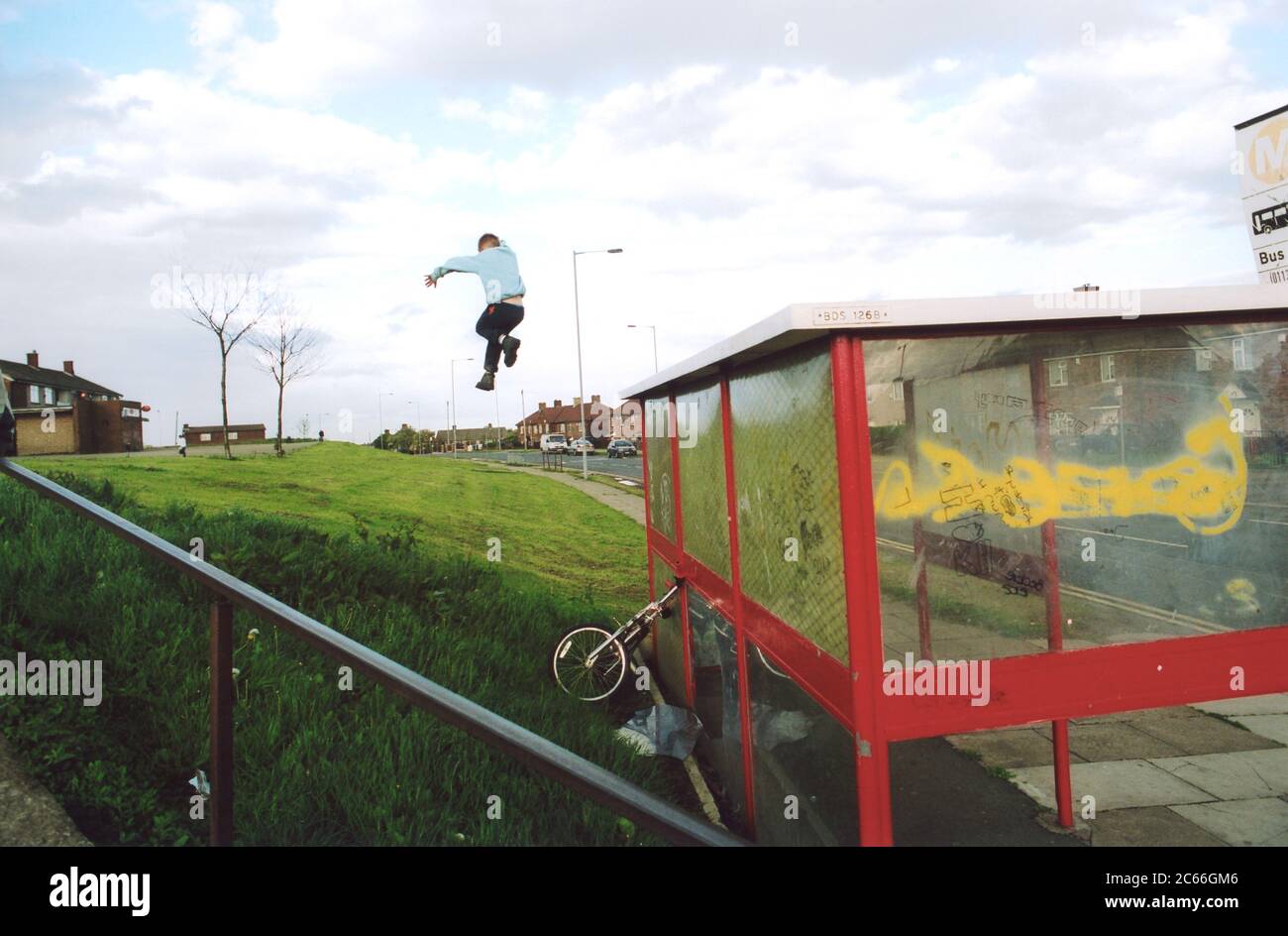 Boy jumping off bus shelter; Bradford council estate; UK Stock Photo
