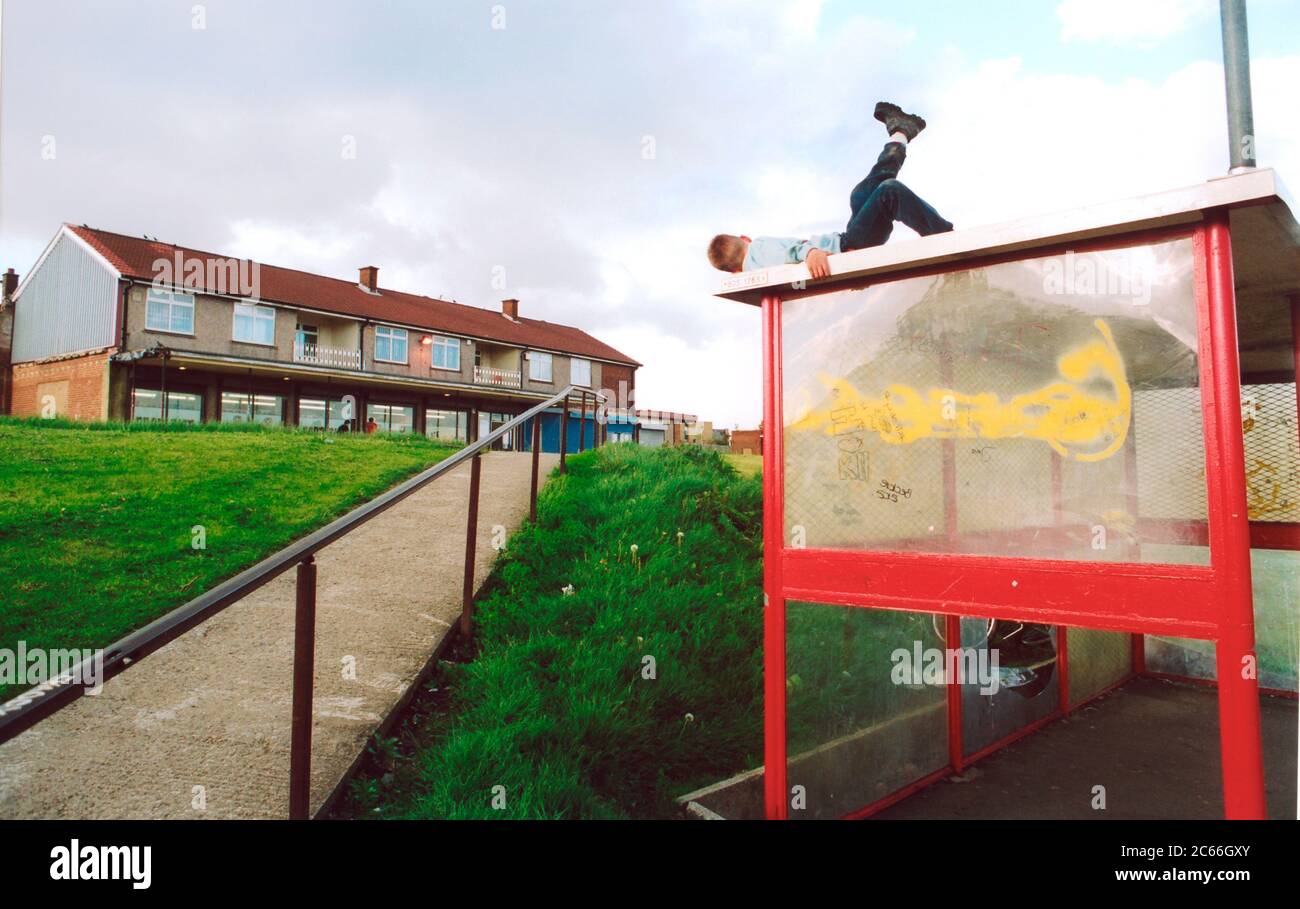 Boy playing on top of bus shelter; Bradford council estate; UK Stock Photo
