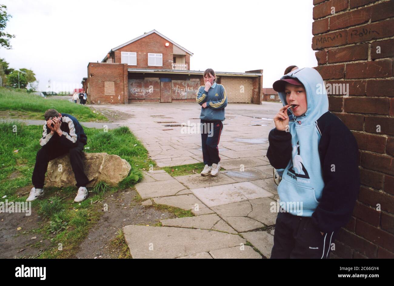 Teenage children hanging around outside youth club; run down council housing estate; Bradford UK Stock Photo