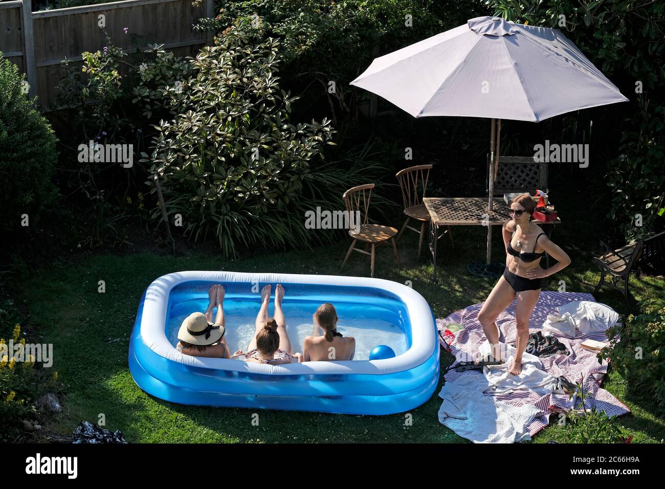 Mother and adult children in paddling pool. Stock Photo