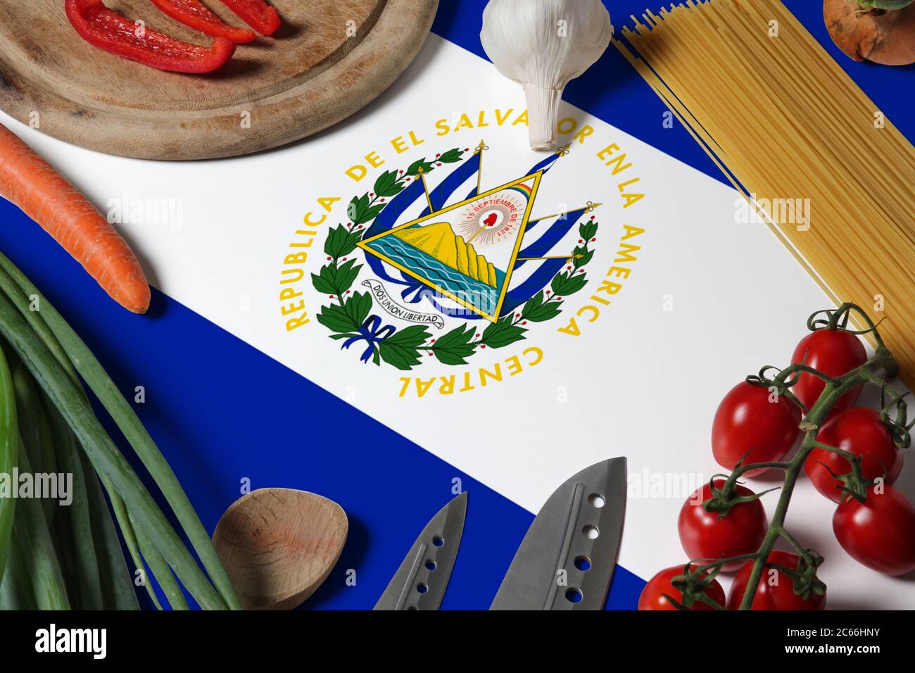 El Salvador flag on fresh vegetables and knife concept wooden table. Cooking concept with preparing background theme. Stock Photo