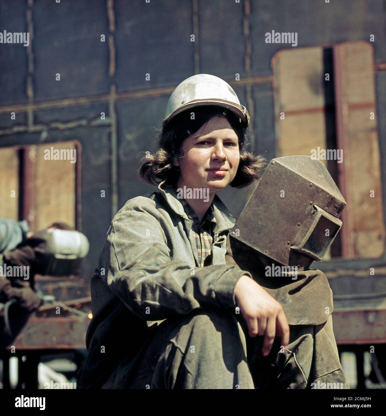 Young female welder at work in VEB Warnowwerft Warnemünde, Publicly Owned Enterprise, the largest shipyard of the GDR Stock Photo