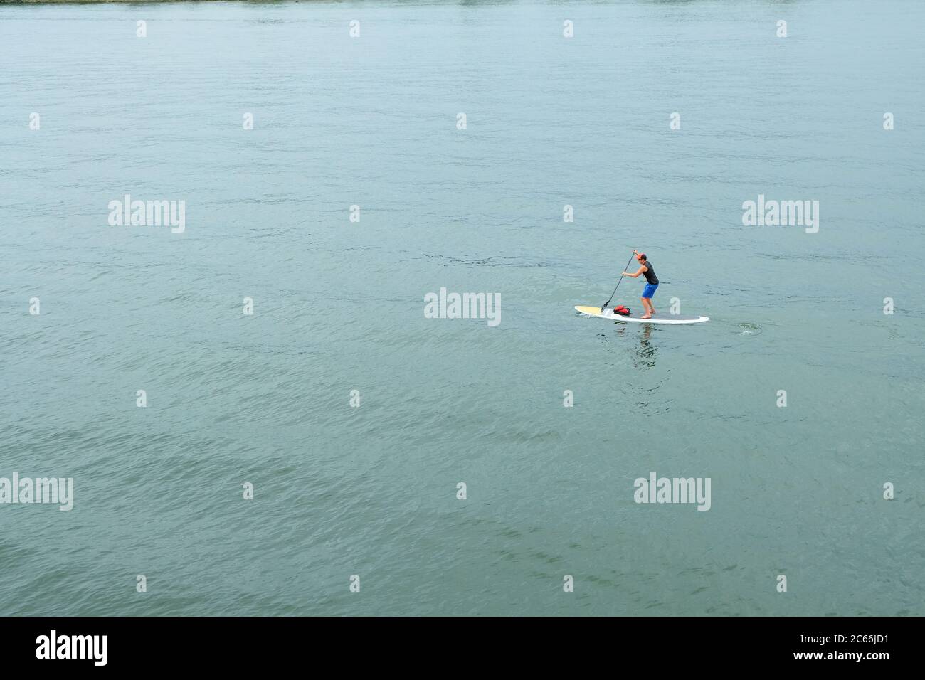 Single man standing on a paddleboard on the Willamette River in Portland Oregon; paddleboarding. Stock Photo