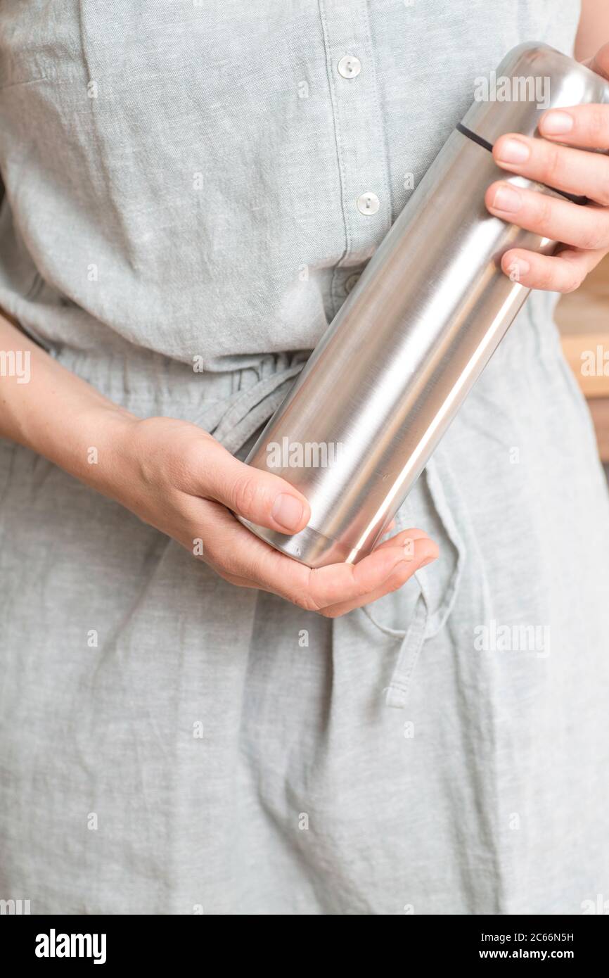 Make your own Ayurveda drink: Woman holding thermos flask with Ayurveda drink in her hands Stock Photo