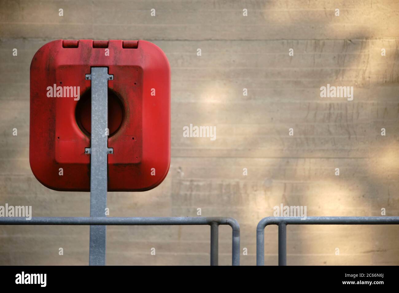 Emergency equipment with a lifebuoy on the railing and the outer wall of a weir, Stock Photo