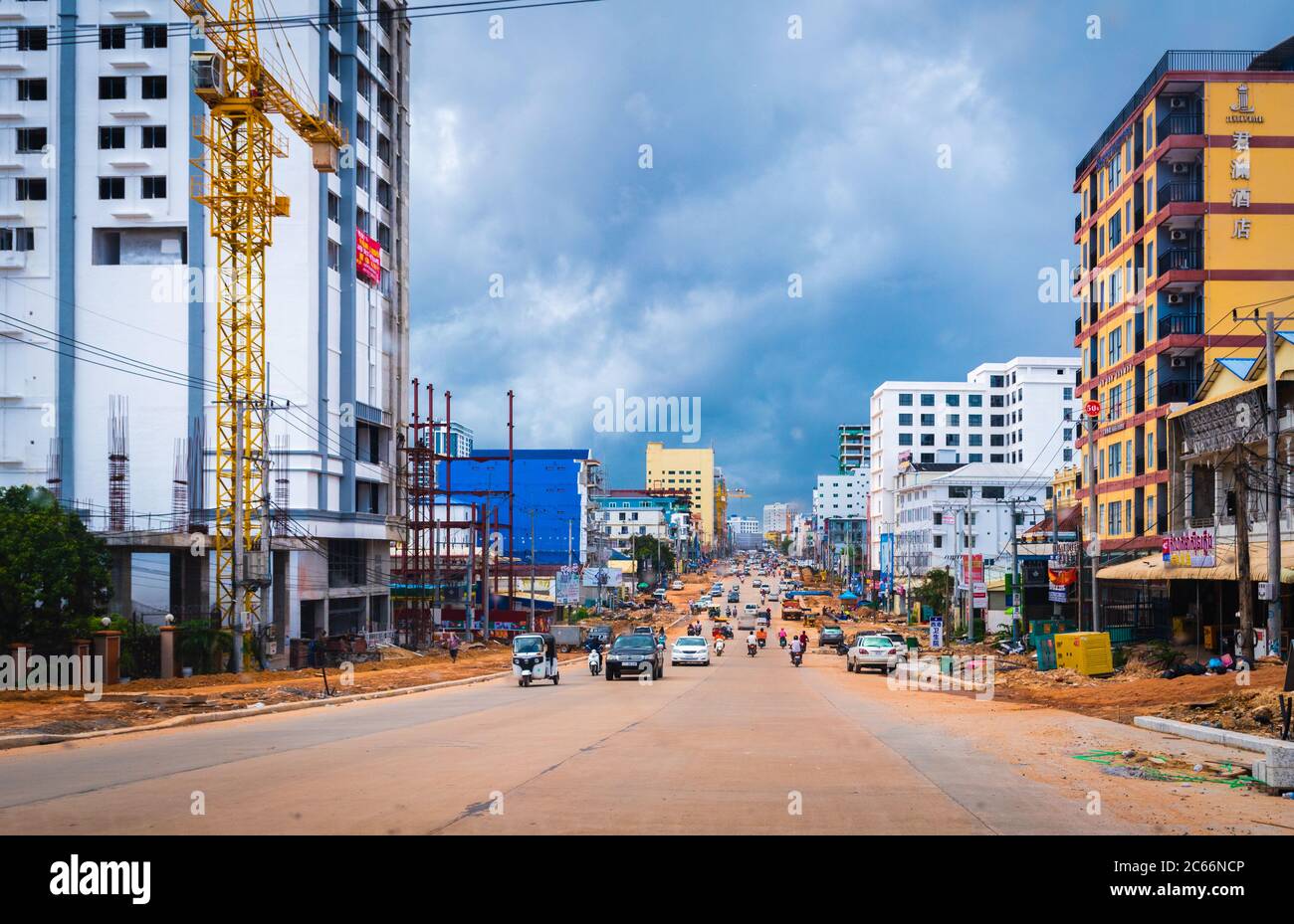 Sihanoukville, Cambodia- July 06, 2020: Traffic on city road under construction during coronavirus pandemic. High rise building under development alon Stock Photo