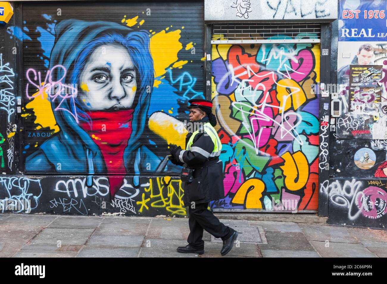 England, London, Shorditch, Brick Lane, Parking Warden Walking Past Street Art and Graffiti Stock Photo