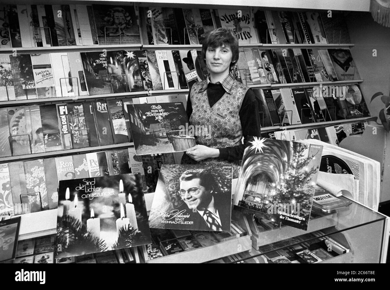 15 December 1986, Saxony, Eilenburg: Long playing records at Christmas time, among other things, with Peter Schreier and the Thomaner, offers in Dezmeber 1986 a young saleswoman in the record shop Eilenburg. An LP from Amiga cost 16.10 marks. Exact recording date not known. Photo: Volkmar Heinz/dpa-Zentralbild/ZB Stock Photo