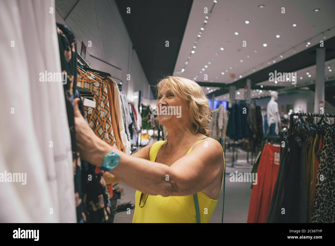 a mature woman choosing clothes in a fashion clothes shop Stock Photo