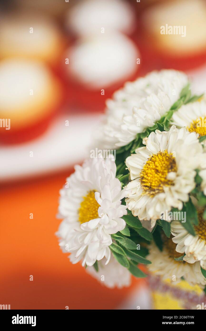 daisies in a tea table close to the sweets Stock Photo