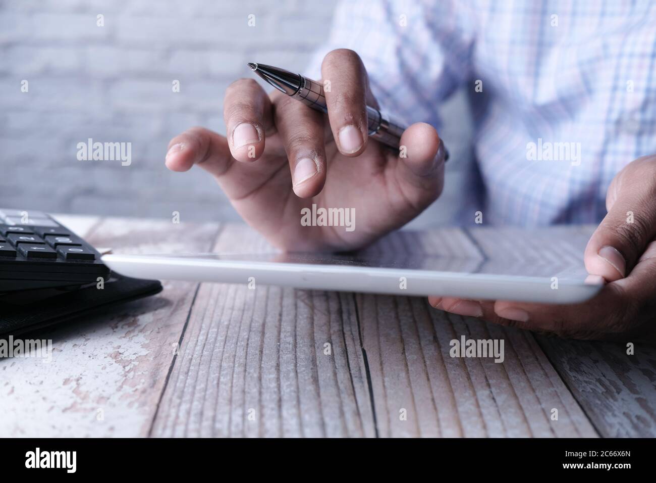 man's hand working on digital tablet at office desk, using self created ...