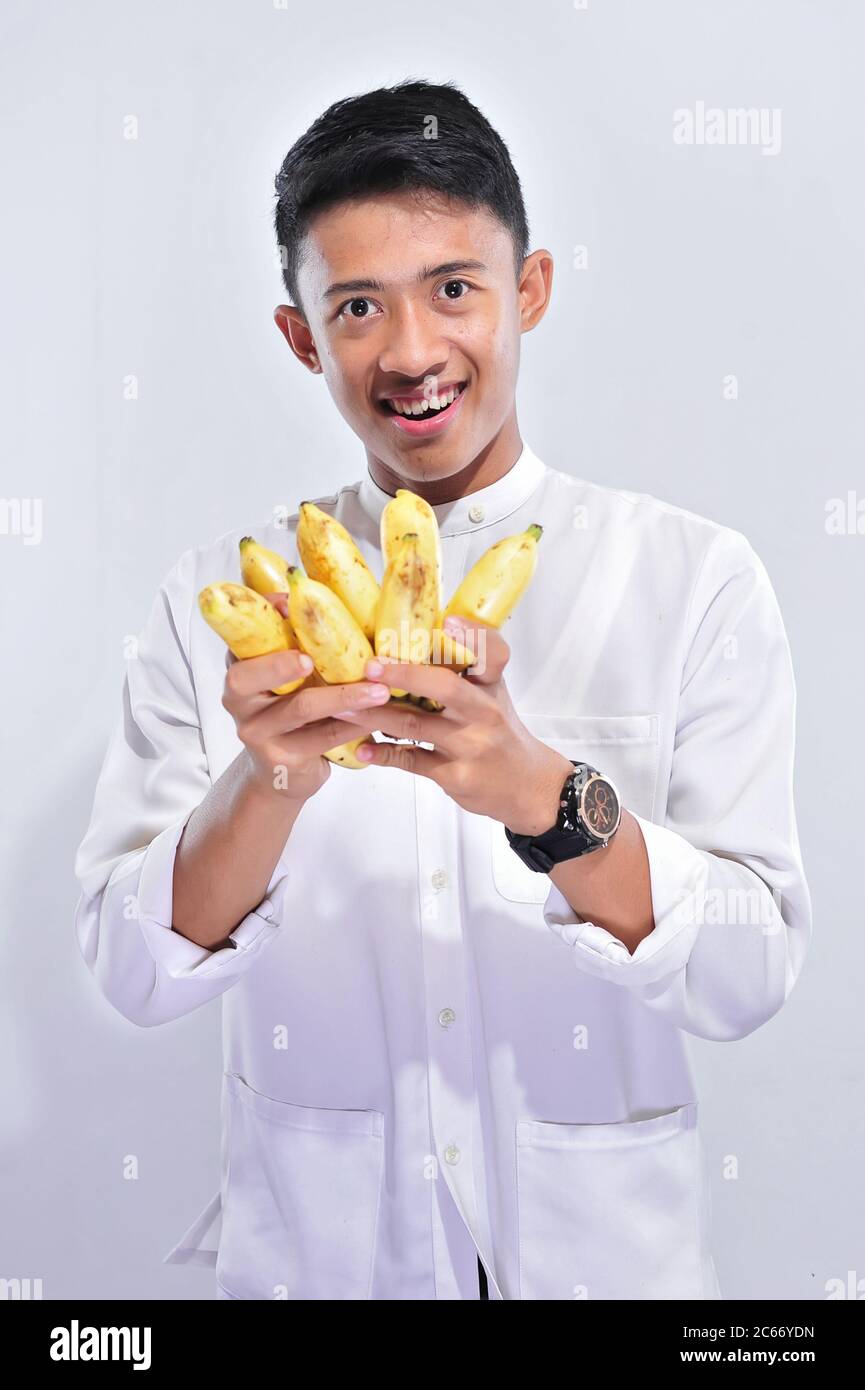 Young muslim man happy fasting when breaking the fast (Iftar) and suhoor eat yellow banana