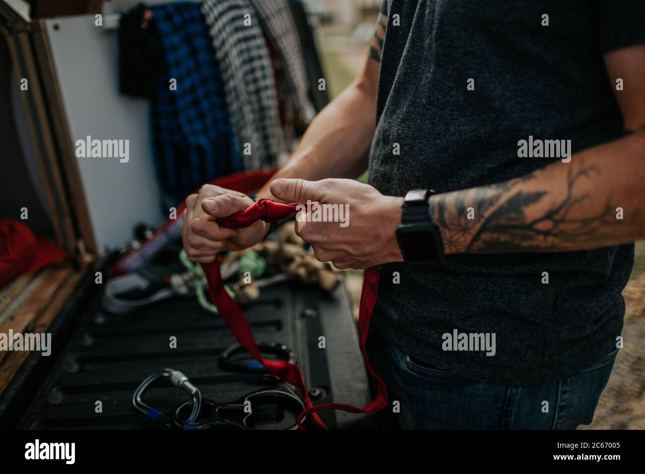 Man tightening knots on climbing ropes Stock Photo Alamy