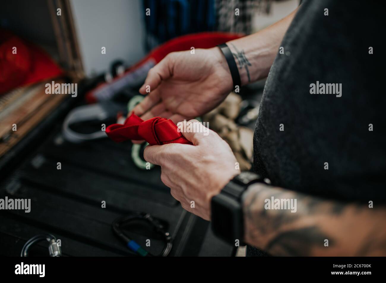 man tying knot in red safety rope Stock Photo - Alamy