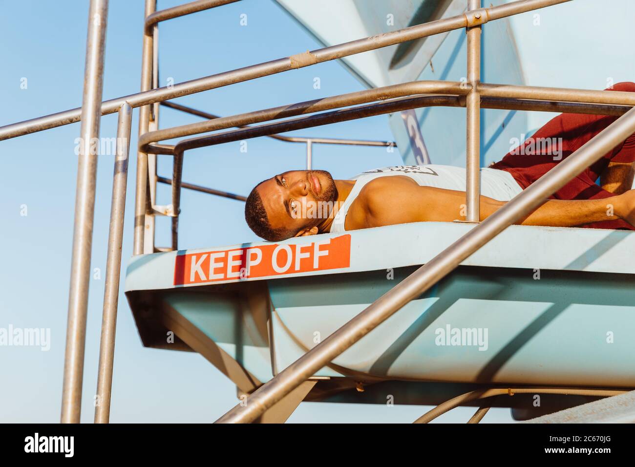 portrait of male athlete relaxing on lifeguard tower Stock Photo