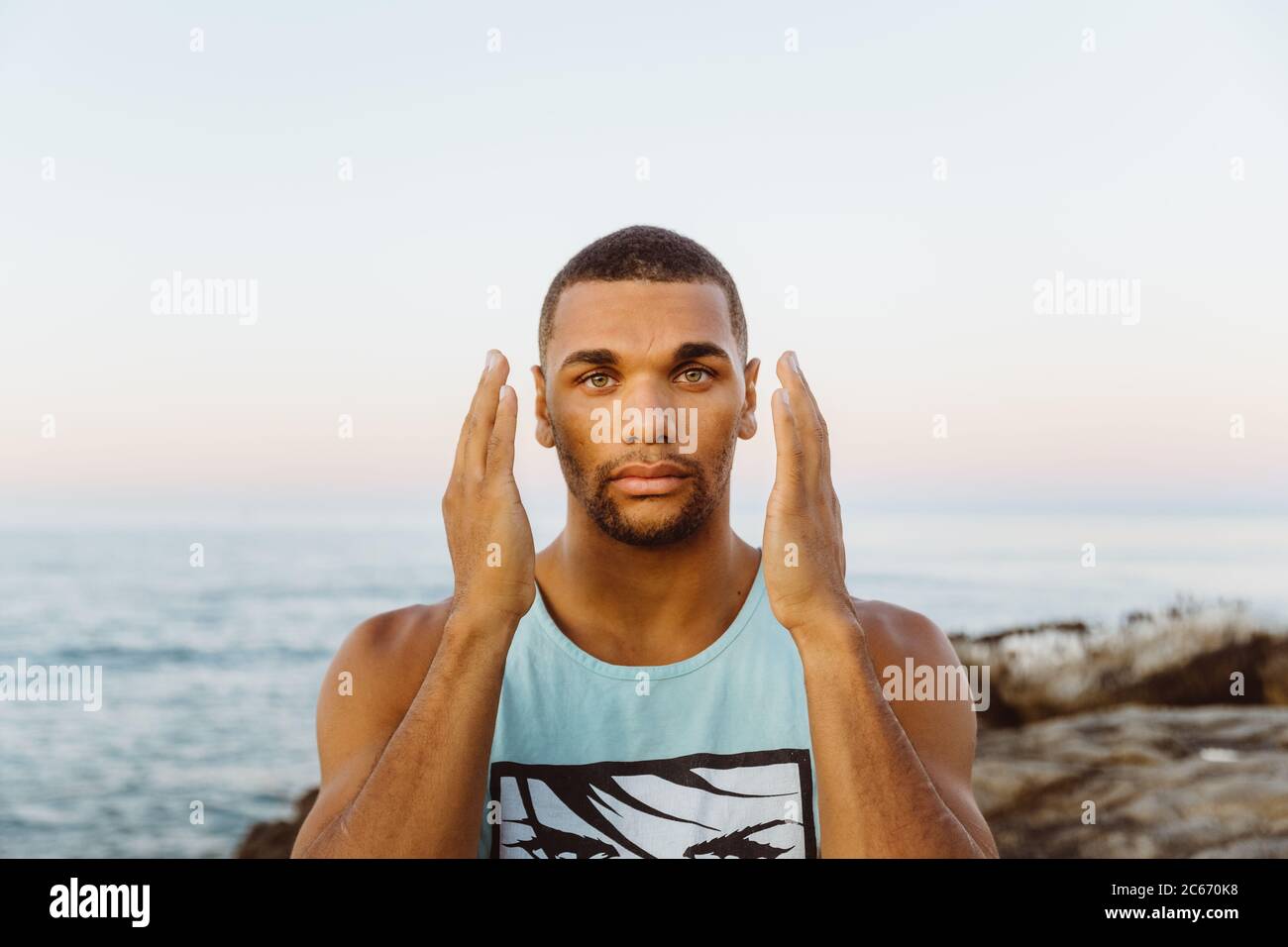 engaging portrait of male athlete with hands next to his cheeks Stock Photo