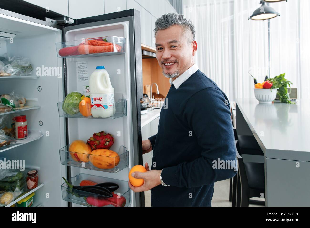 Middle-aged and old man open the fridge fruit Stock Photo
