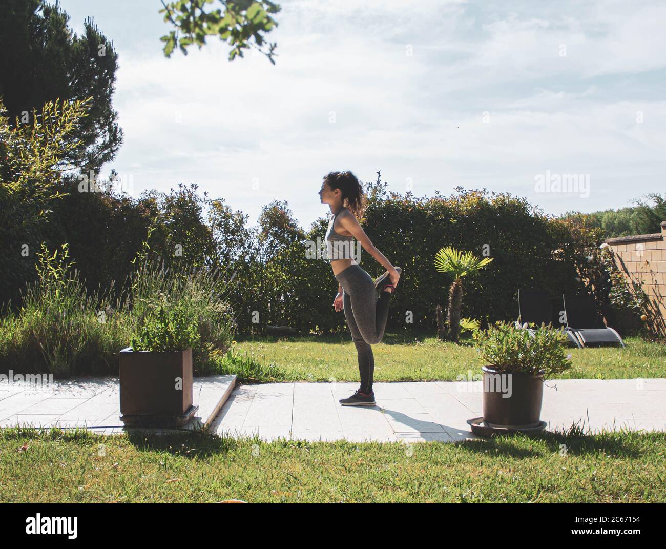 young woman exercising in her home garden Stock Photo
