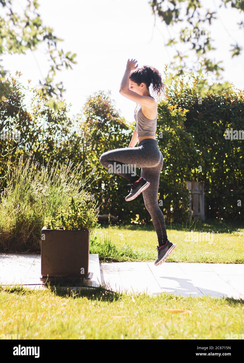 young woman exercising in her home garden Stock Photo