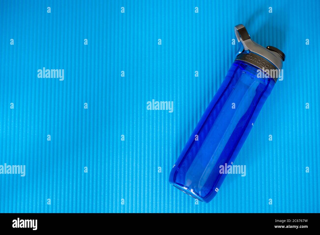 Blue BPA free Contigo water bottle on a fitness mat. Stock Photo