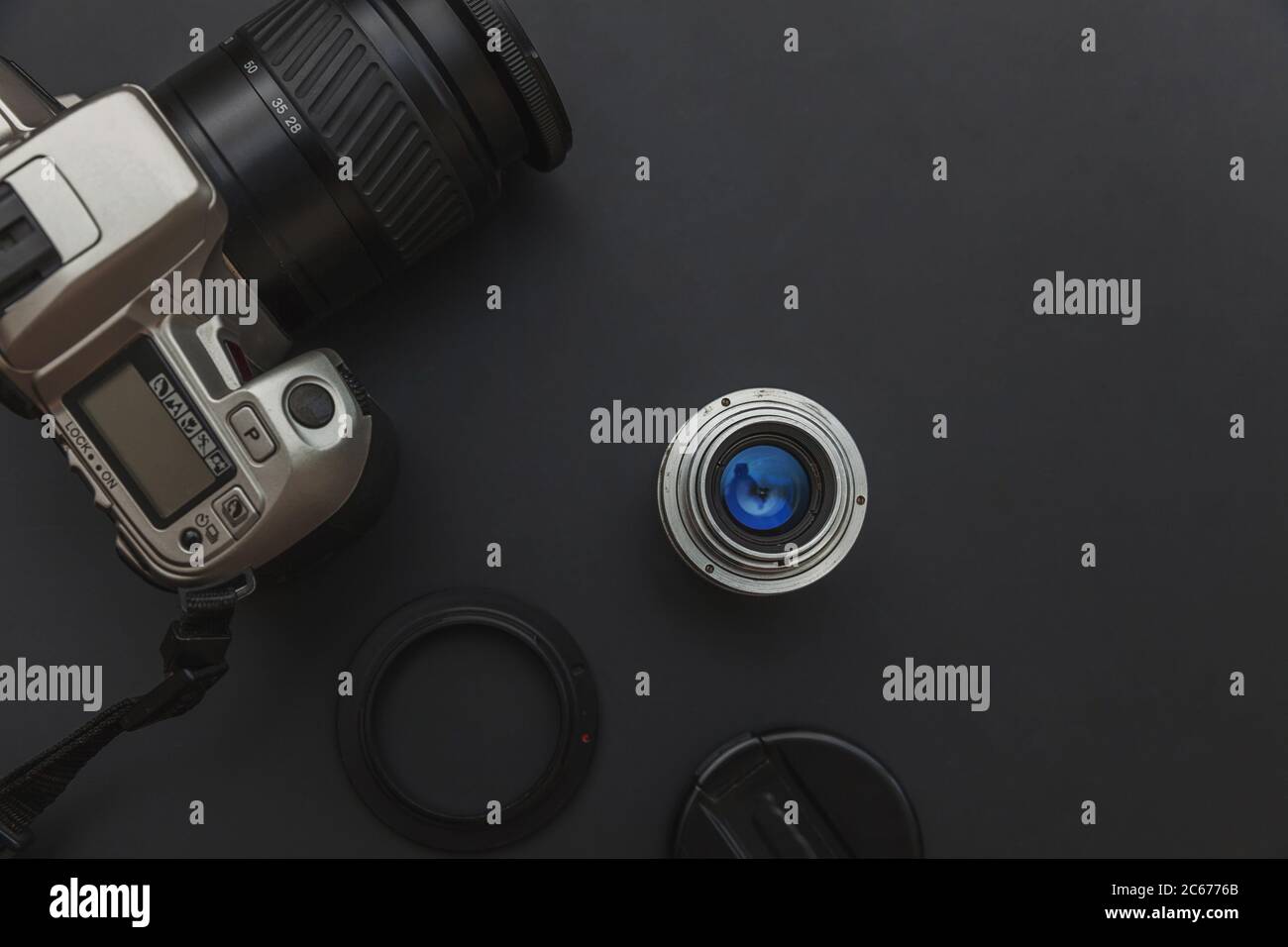 Photographer workplace with dslr camera system and lens on dark black ...