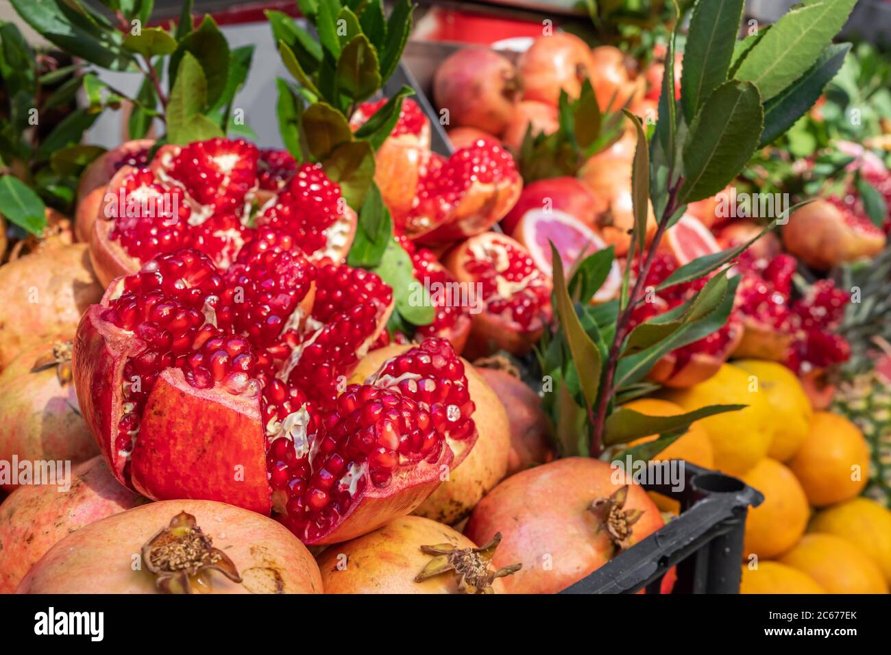 Ripe and juicy half peeled pomegranates ready to be squeezed for fresh juice Stock Photo