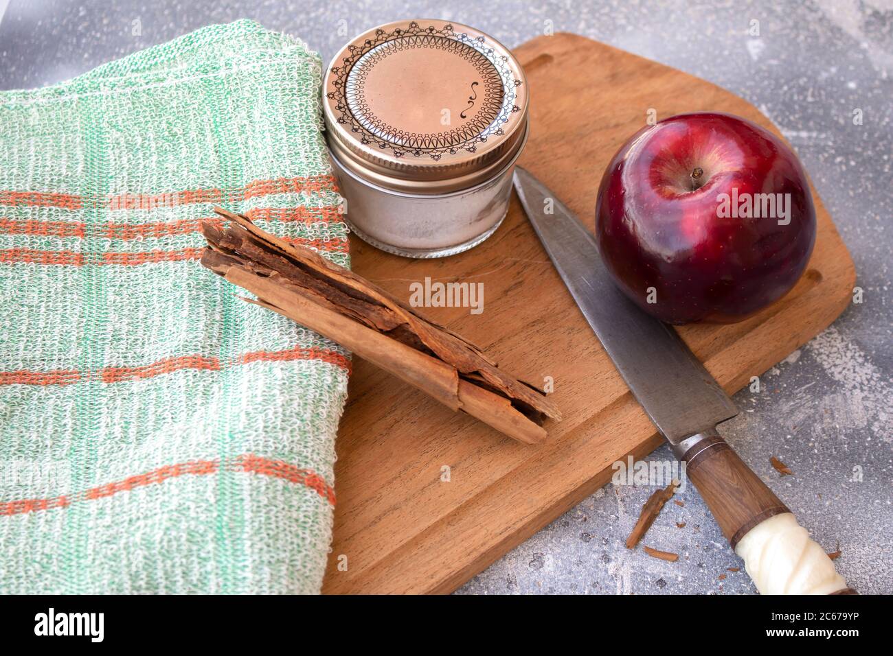 Red apple, knife, sugar and cinnamon on Wooden table Stock Photo